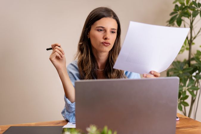Focused Woman Reviewing Documents in Home Office - Professional Remote Work