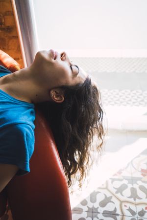 Young woman relaxing on sofa with closed eyes