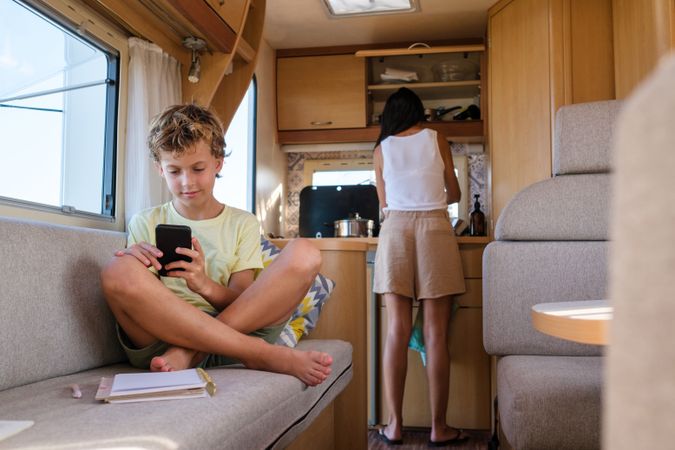 Boy using smartphone in camper