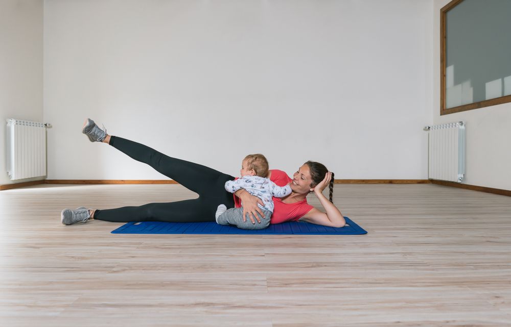 Mother exercising with baby in gym