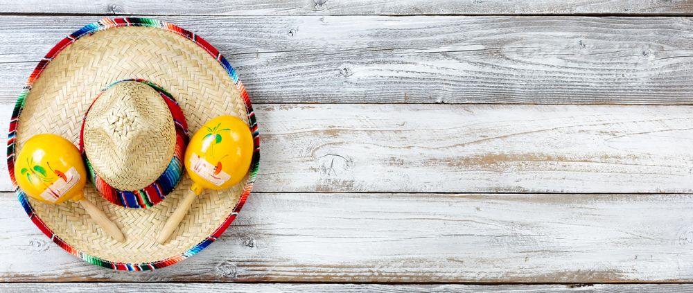 Flat lay view of traditional Cinco De Mayo objects on white weathered wood