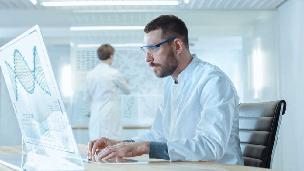 In the Futuristic Laboratory Male Scientists Working on the Transparent Display Computer.