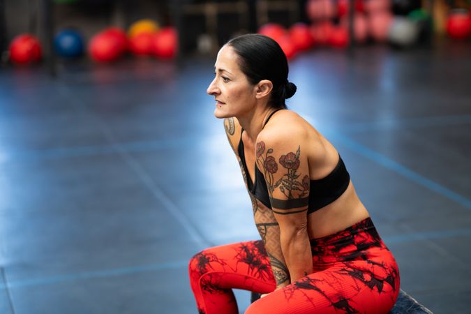 Fit woman sitting on a box resting after training with copy space