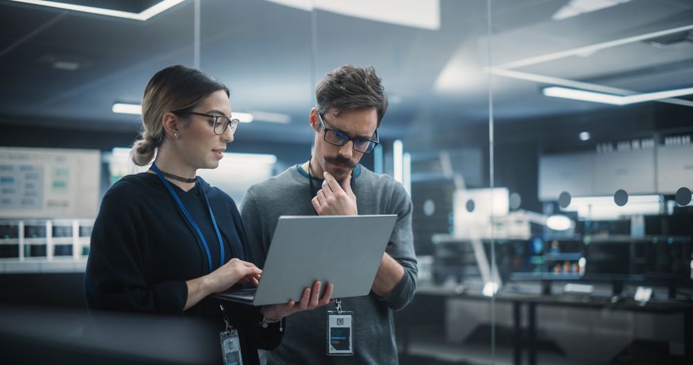 Multicultural Chief Technology Officer Talking to Software Developer, Discussing Neural Network Updates in High Tech Research and Development Facility.