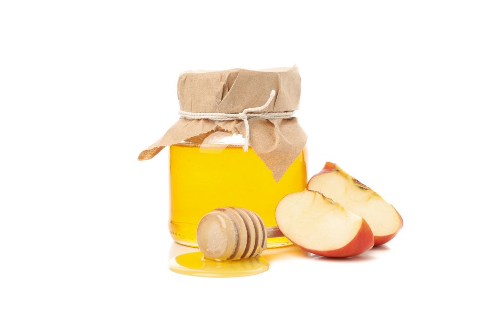 Pot of honey with apple quarters