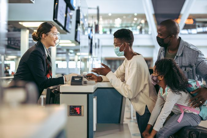 Black family in covid-19 outbreak at check-in desk of airport