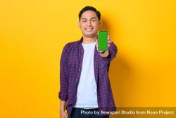 Happy Asian man in plaid shirt  holding smartphone with chroma key 5oYngb