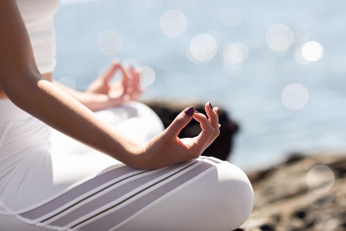 Close up of hands of a woman meditating at the beach