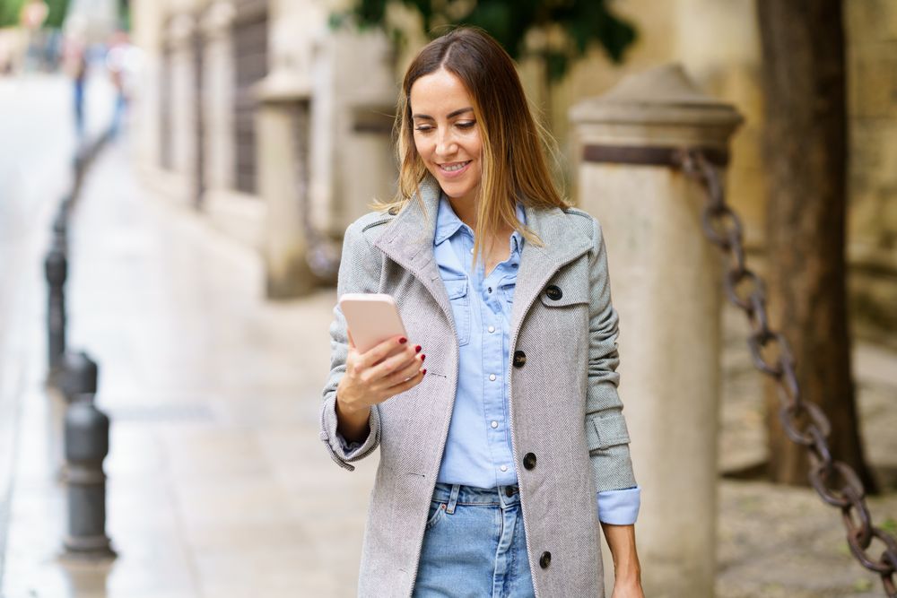 Smiling female watching video on city street
