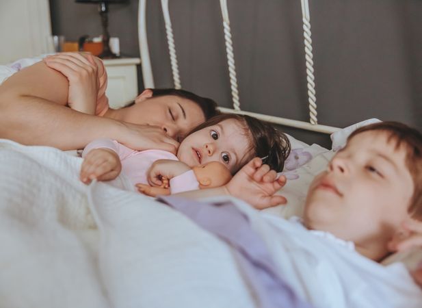 Woman sleeping with young son and daughter