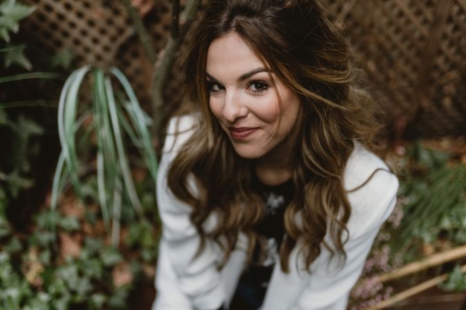 Woman sitting on planter in garden