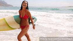 Woman laughing and holding surfboard 5qqWa5
