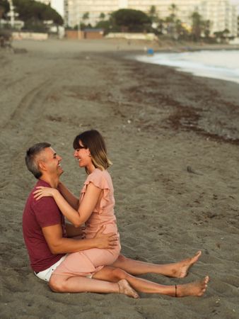Delighted couple sitting on beach