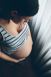 Pregnant woman looking her belly