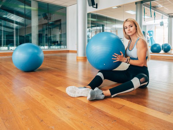 Female athlete with fitness ball on floor