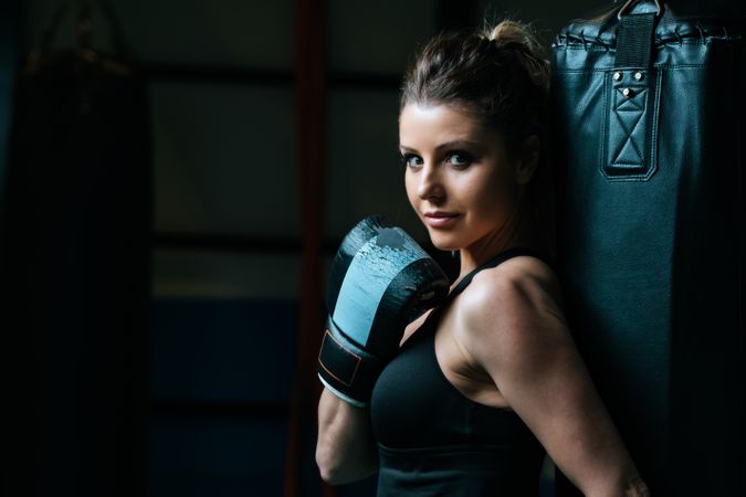 Sportswoman in boxing gloves in gym