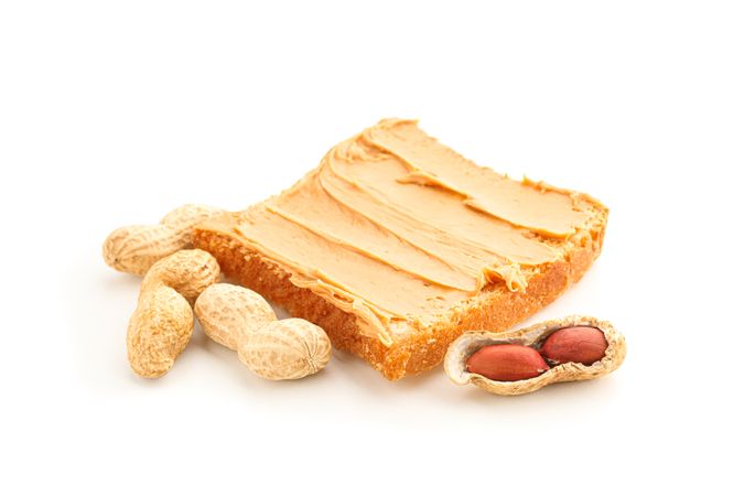 Peanut butter sandwich and peanut isolated on light background. A traditional product of American cuisine