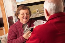 Happy Adult Couple Playing Cards in Their Trailer RV