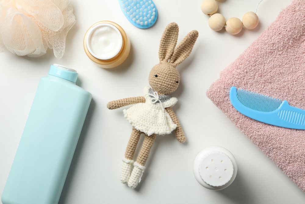 Baby hygiene accessories on light background, top view
