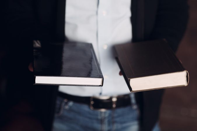 Cropped image of man holding two books