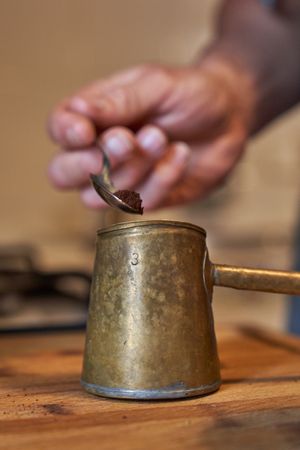 Anonymous man preparing coffee in cezve