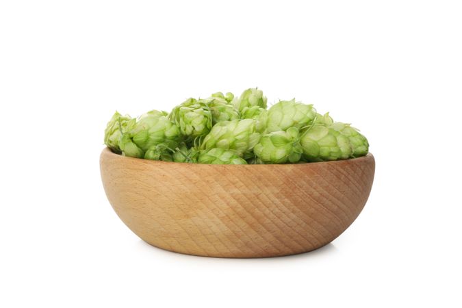 Wooden bowl with hop isolated on light background
