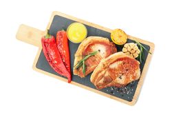 Board with fried steaks and vegetables isolated on blank background
