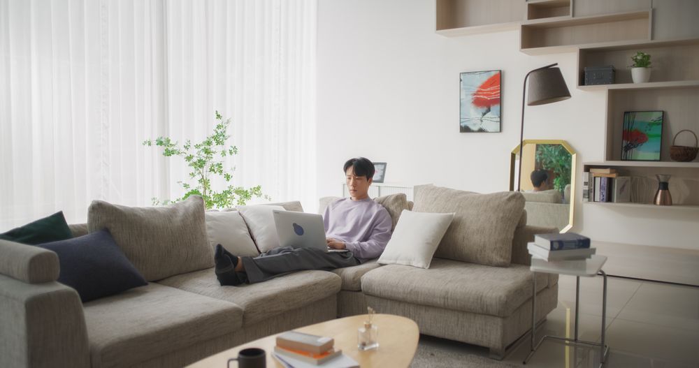 Focused South Korean Professional Enjoying Telecommuting, Working on His Laptop Computer in the Comfort of Home