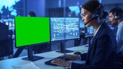 IT Specialist Monitors Systems in Blue-lit Control Room.