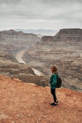 Female relaxing on cliff and admiring picturesque view