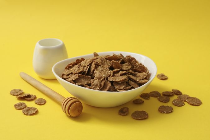 Dipper and bowl of muesli on yellow background