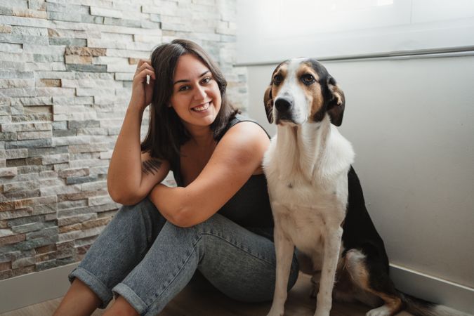 Woman with dog sitting on floor