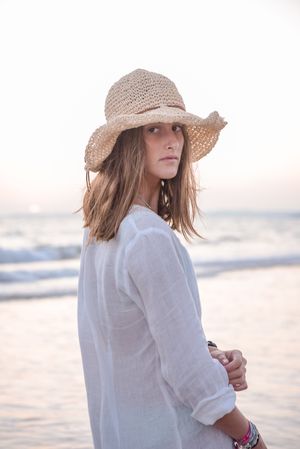 Woman in light white dress on wavy beach