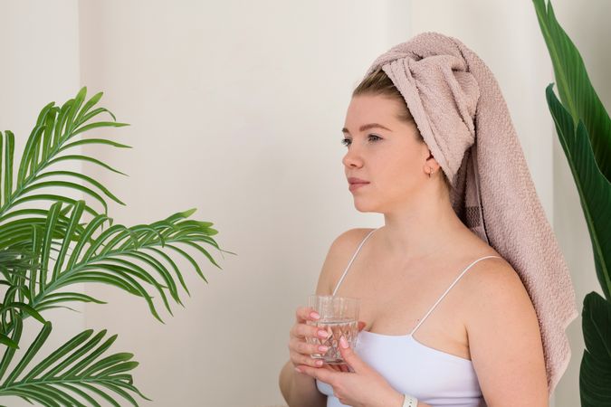 Woman drinking water after skincare.