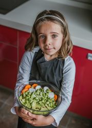 Girl with vegetable salad in kitchen