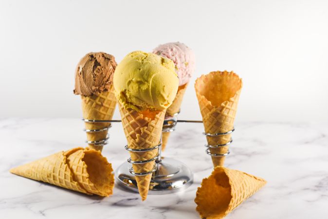 Ice cream cone stand with waffle cones and three different scoops
