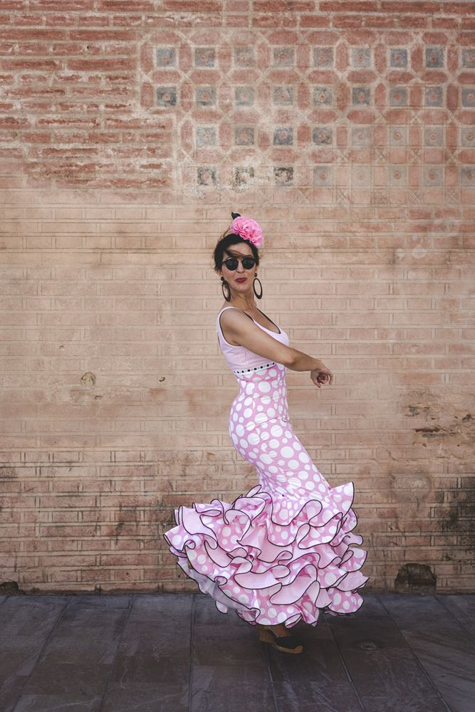 Passionate woman in flamenco dress dancing on street