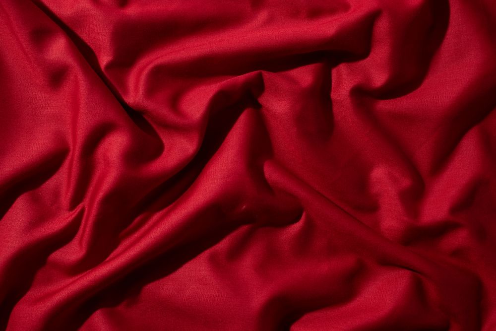 Crumpled wavy Red silky fabric background texture.