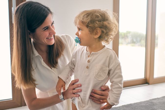 Happy woman and toddler looking at each other and smiling