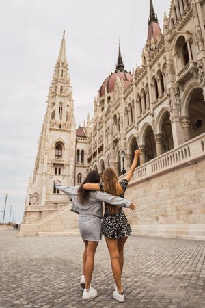 Funny girl friends on old square with dome buildings