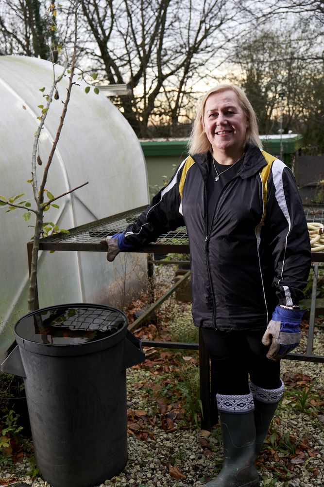 Older woman gardening outside, vertical