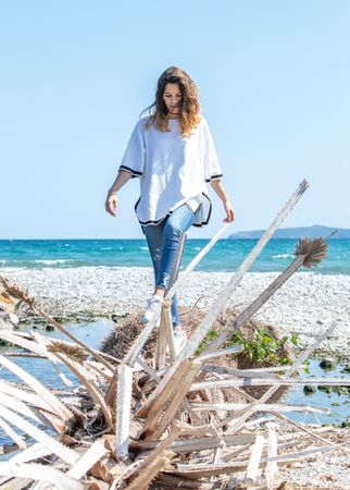 Young woman walking near dried plants