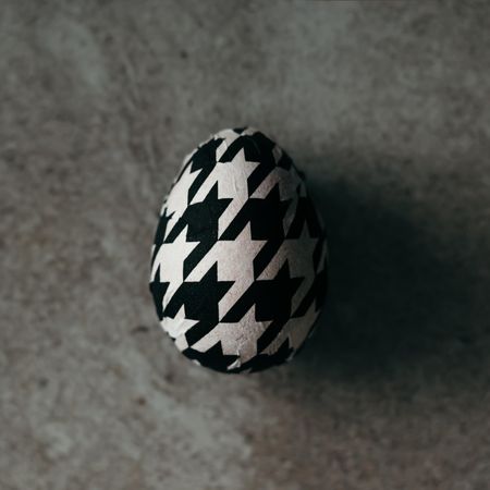 Houndstooth egg top view on stone background