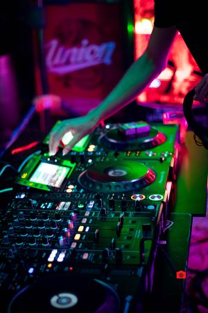 DJ playing music on audio mixer