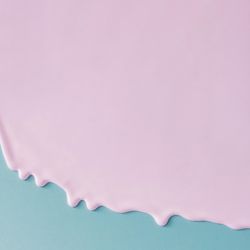 Abstract pink oil paint dripping texture on blue canvas