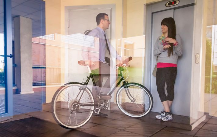 Businessman and sportive Woman waving behind glass