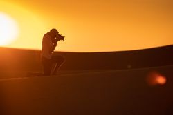 Anonymous photographer standing in desert