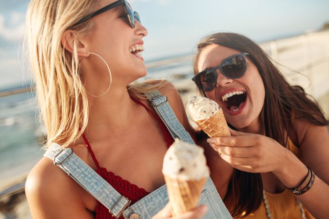 Close up of young women eating ice cream and laughing