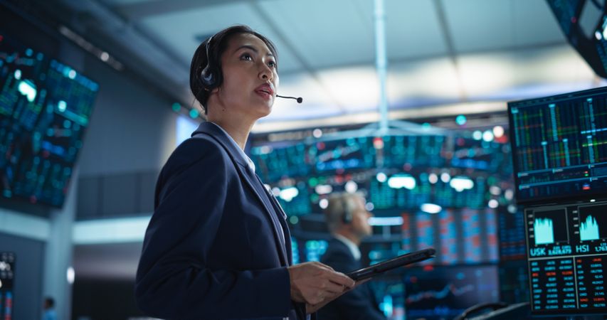 Successful Stock Exchange Manager Wearing Headphones, Working in Modern Office.