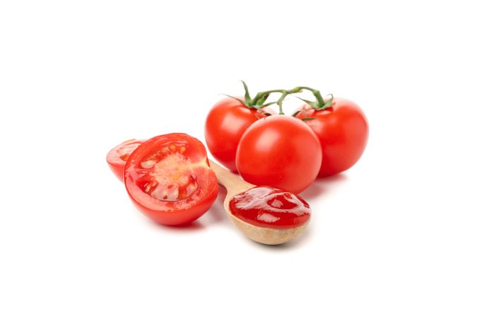 Tomatoes and spoon with sauce isolated on neutral background